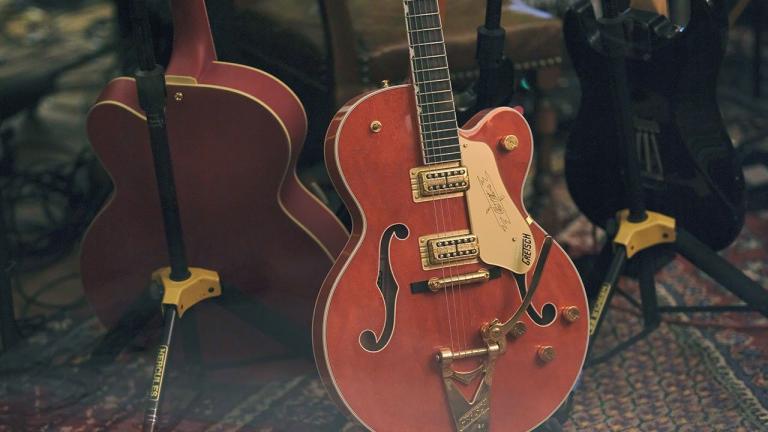 Two electric guitars positioned on an old carpet